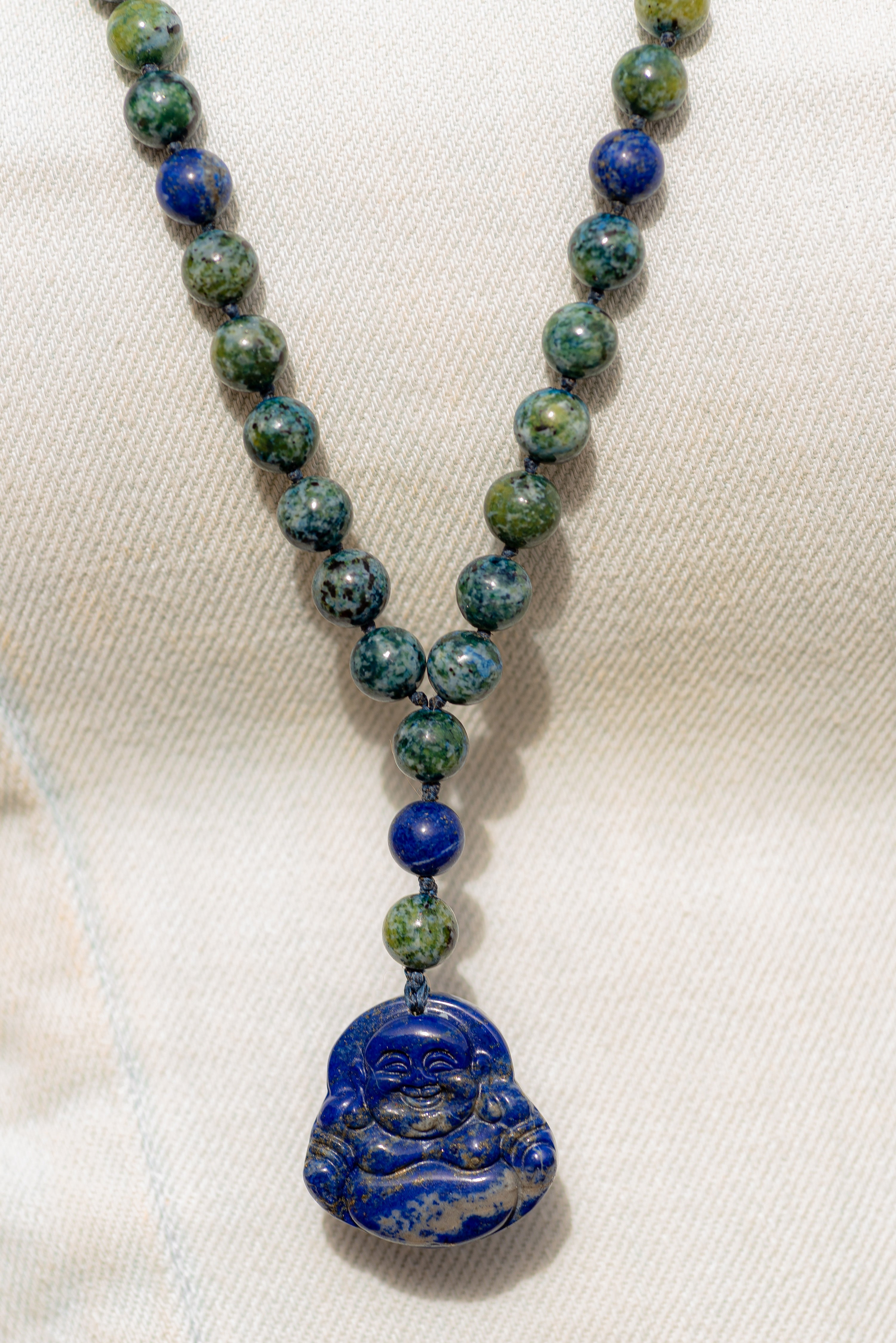 Buddah Lapis lazuli pendant with azurite and lapis lazuli beads .